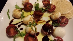 Mini mozzarella balls with cherry tomatoes drizzled with olive oil and balsamic reduction and showered with a basil chiffonade (Photo Credit: Adroit Ideals)