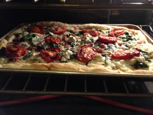 Roasted tomato and asparagus pizza baking in the oven! (Photo Credit: Adroit Ideals)