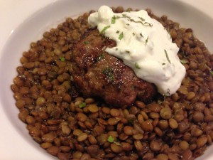 Grilled Lamb Burger over Lentils with Minty Yogurt Sauce and garnished with Mint Chiffonade (Photo Credit: Adroit Ideals)