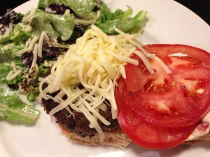 Spicy black bean burger with shredded Monterey Jack and a chipotle cream sauce.  Side Caesar salad.  (Photo Credit: Adroit Ideals)