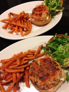 Salmon burgers with spinach and feta on wheat buns with garlic aioli and shredded Romaine.  Served with sweet potato fries.  (Photo Credit: Adroit Ideals)