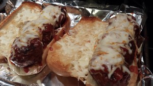 Broil the meatball sandwiches for a few minutes until the cheese melts (Photo Credit: Adroit Ideals)