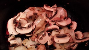 Add the mushrooms to the onions  (Photo Credit: Adroit Ideals)
