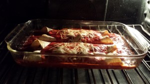 Tasty Smoked Pork Enchiladas are baking and bubbling in the oven (Photo Credit: Adroit Ideals)