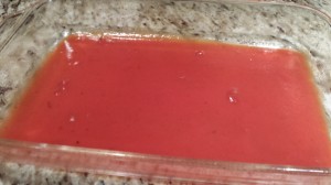 After spraying the baking dish with cooking spray, cover the bottom with a coating of enchilada sauce (Photo Credit: Adroit Ideals)