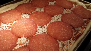Add thinly sliced pepperoni to the pizza (Photo Credit: Adroit Ideals)