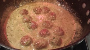 Add the turkey meatballs to the sauce, then add the basil pesto, and warm through.  (Photo Credit: Adroit Ideals)