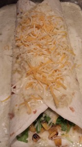 Top the enchilada with more shredded cheese  (Photo Credit: Adroit Ideals)