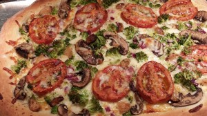 Tomato, mushroom, and broccoli pizza with roasted garlic cloves  (Photo Credit: Adroit Ideals)