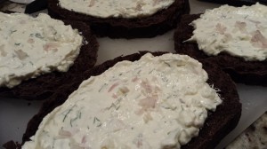Spread the herbed cream cheese mixture on the pumpernickel slices (Photo Credit: Adroit Ideals)