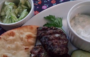 Serve the grilled lamb meatball patties with a cucumber Greek yogurt sauce and a cool lemony cucumber dill salad. (Photo Credit: Adroit Ideals)