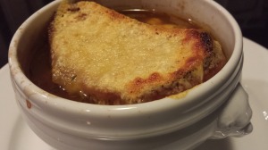 Baked Onion Thyme Soup crowned with a Toasted Crouton with Melted Swiss Cheese (Photo Credit: Adroit Ideals)