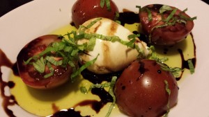 Ripe Tomato Salad with a creamy Burrata cheese ball drizzled with balsamic vinegar syrup and olive oil (Photo Credit: Adroit Ideals)