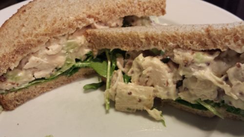 Honey Mustard Chicken Salad spilling out of Whole Grain Bread with Arugula (Photo Credit: Adroit Ideals)