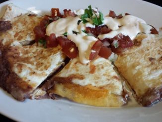 Melty Four Cheese and Black Refried Bean Quesadilla topped with Pico de Gallo and Chipotle Cream Dressing
