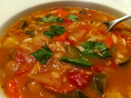 A spoon scoops up Minestrone Soup